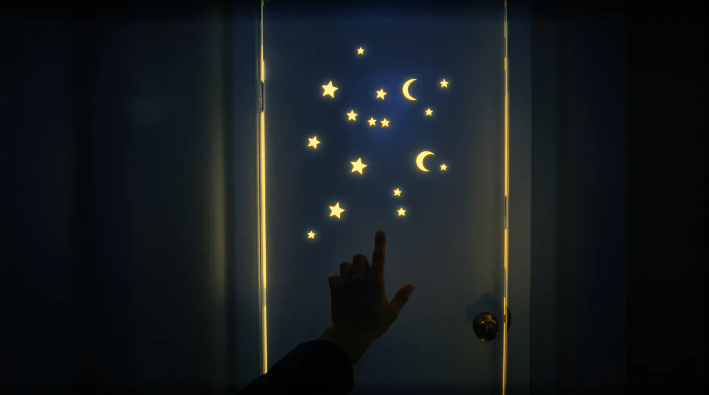 A closed bedroom door with glow-in-the-dark stars, warm light at its edges, a father's hand reaching toward it.
